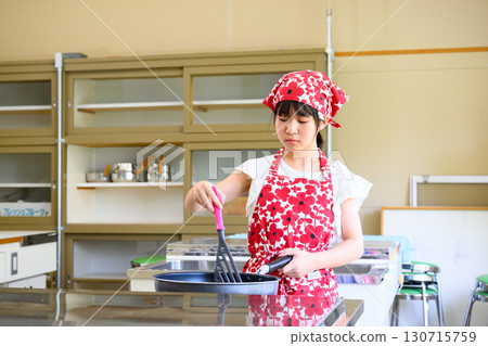 Elementary school girl learning cooking at cooking class and cooking teacher Education and food education image 130715759