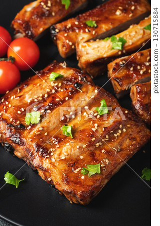 Hot grilled spare ribs from a summer BBQ served on a plate with sauce. Top view. Copy space Hot grilled spare ribs from a summer BBQ served on a plate with sauce. Top view. Copy space 130715884