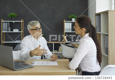 Banking agent discussing a contract with his client during a meeting in the office 130716441