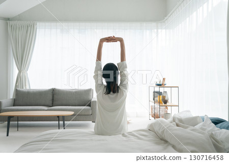 A woman stretching in bed A woman stretching in bed 130716458