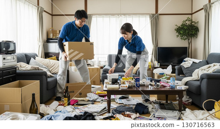 兩名工人，一男一女，正在打掃凌亂的房間。 130716563
