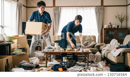 兩名工人，一男一女，正在打掃凌亂的房間。 130716564