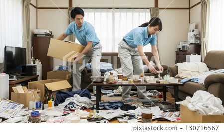 Two workers, a man and a woman, cleaning up a messy room. Two workers, a man and a woman, cleaning up a messy room. 130716567