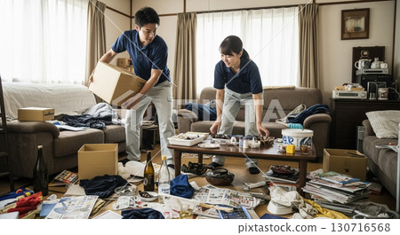 兩名工人，一男一女，正在打掃凌亂的房間。 130716568