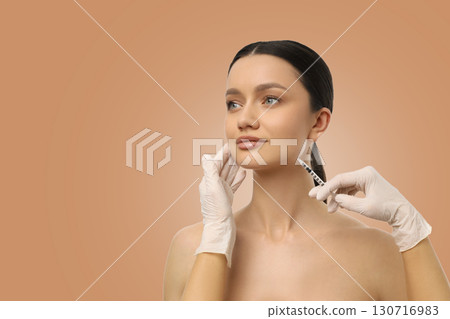 A professional performs an injectable treatment on a womans face A professional performs an injectable treatment on a womans face 130716983
