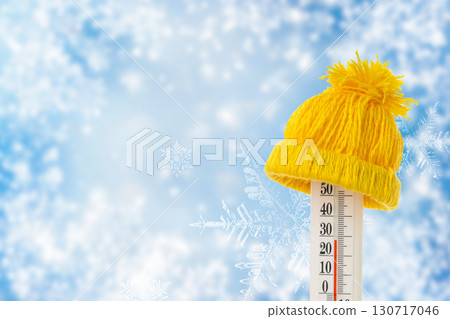 Thermometer shows low temperatures with a warm hat on top Thermometer shows low temperatures with a warm hat on top 130717046