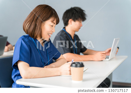 Male and female medical staff in scrubs attending medical conferences, study sessions, seminars, training sessions Male and female medical staff in scrubs attending medical conferences, study sessions, seminars, training sessions 130717517