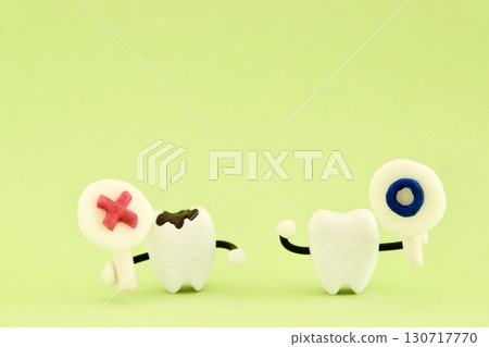 A miniature tooth with a circle and a miniature cavity with an X, lined up horizontally. A miniature tooth with a circle and a miniature cavity with an X, lined up horizontally. 130717770