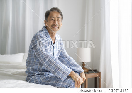 A man in his 60s wearing pajamas and smiling at the camera 130718185
