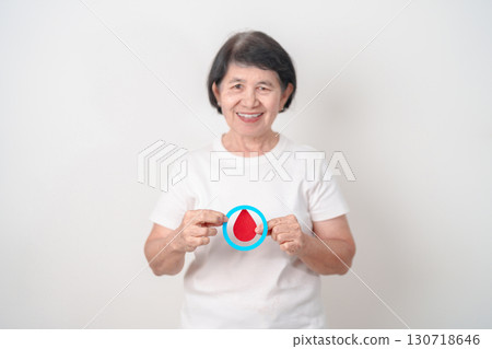 Elderly woman with Blue Circle and red Blood drop for World Diabetes Day, Blue November Health month, Diabetes awareness, Blood sugar check, Insulin, Glucose screening, donation and Health checkup 130718646
