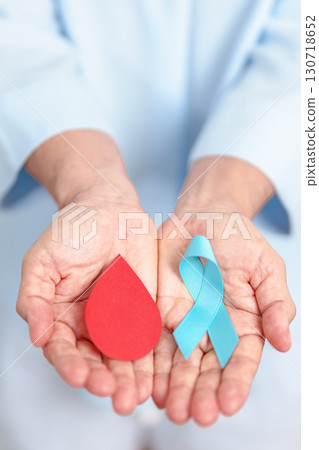Elderly woman with Blue ribbon and red Blood drop for World Diabetes Day, Blue November Health, Prostate Cancer awareness, Blood sugar check, Insulin, Glucose screening, donation and Health checkup 130718652