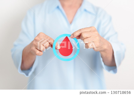 Elderly woman with Blue Circle and red Blood drop for World Diabetes Day, Blue November Health month, Diabetes awareness, Blood sugar check, Insulin, Glucose screening, donation and Health checkup 130718656