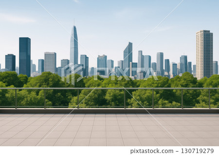 Open terrace with glass railing overlooking city skyline and green trees under clear sky, modern urban lifestyle with peaceful and fresh atmosphere 130719279