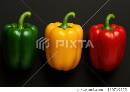 Three bell peppers green yellow red on black background with fresh vibrant colors and smooth texture, perfect for healthy cooking and colorful food presentation 130719555