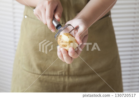 Woman peeling potatoes Woman peeling potatoes 130720517