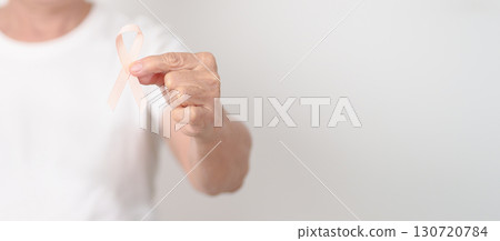 Elderly woman with Peach Ribbon for September Uterine Cancer Awareness month, Endometrial Cancer, Gynecologic, Uterus and Ovaries, Endometriosis, June Vaginal cancer and World cancer day concept 130720784