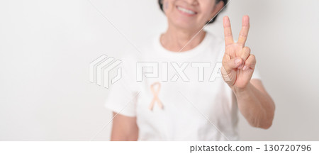 Elderly woman with Peach Ribbon for September Uterine Cancer Awareness month, Endometrial Cancer, Gynecologic, Uterus and Ovaries, Endometriosis, June Vaginal cancer and World cancer day concept 130720796