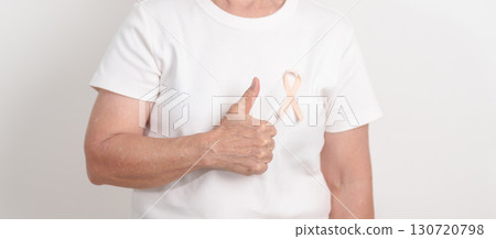 Elderly woman with Peach Ribbon for September Uterine Cancer Awareness month, Endometrial Cancer, Gynecologic, Uterus and Ovaries, Endometriosis, June Vaginal cancer and World cancer day concept 130720798