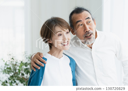 Senior couple looking outside by the window Senior couple looking outside by the window 130720829