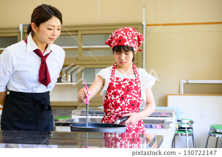 Elementary school girl learning cooking at cooking class and cooking teacher Education and food education image 130722147