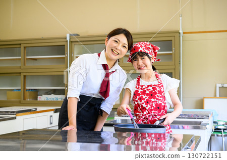 Elementary school girl learning cooking at cooking class and cooking teacher Education and food education image 130722151