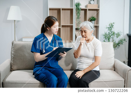 Asian caregiver doctor examine older patient woman therapist nurse at nursing home taking care of senior elderly woman sit on sofa.Medical service concept. Asian caregiver doctor examine older patient woman therapist nurse at nursing home taking care of senior elderly woman sit on sofa.Medical service concept. 130722206