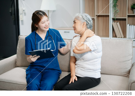 Asian caregiver doctor examine older patient woman therapist nurse at nursing home taking care of senior elderly woman sit on sofa.Medical service concept. 130722208