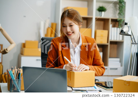 Young woman running online store Startup small business SME, using smartphone or tablet taking receive and checking Young woman running online store Startup small business SME, using smartphone or tablet taking receive and checking 130722324