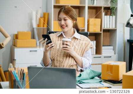 Young woman running online store Startup small business SME, using smartphone or tablet taking receive and checking Young woman running online store Startup small business SME, using smartphone or tablet taking receive and checking 130722326