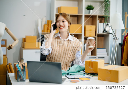 Young  woman prepare parcel box and standing check online orders for deliver to customer on tablet, laptop Shopping Online concept. 130722327