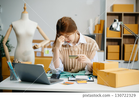 Young  woman prepare parcel box and standing check online orders for deliver to customer on tablet, laptop Shopping Online concept. 130722329