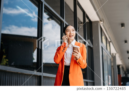 Working woman concept a female manager attending video conference and holding tablet, smatrphone in city Outside Office 130722485