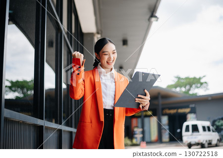 Working woman concept a female manager attending video conference and holding tablet, smatrphone in city Outside Office 130722518