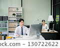 Two young Asian professionals engaged in teamwork and business discussions in modern office embodying corporate 130722622