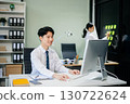 Two young Asian professionals engaged in teamwork and business discussions in modern office embodying corporate 130722624