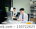 Two young Asian professionals engaged in teamwork and business discussions in modern office embodying corporate 130722625