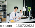 Two young Asian professionals engaged in teamwork and business discussions in modern office embodying corporate 130722628