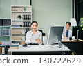 Two young Asian professionals engaged in teamwork and business discussions in modern office embodying corporate 130722629