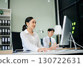 Two young Asian professionals engaged in teamwork and business discussions in modern office embodying corporate 130722631