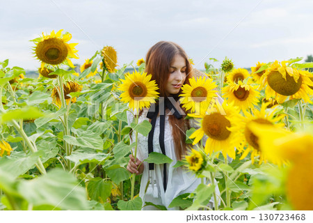 Portrait of a pretty girl in a field of sunflowers. Portrait of a pretty girl in a field of sunflowers. 130723468