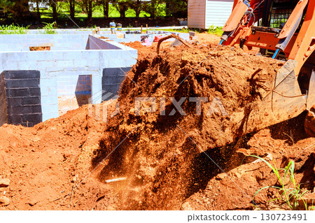 Heavy machinery removes dirt from construction site while preparing for new building foundations. Heavy machinery removes dirt from construction site while preparing for new building foundations. 130723491