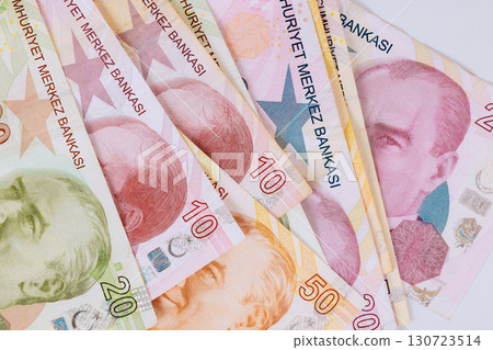 Turkish lira cash banknotes of various denominations are stacked on flat surface, displaying vibrant designs. Turkish lira cash banknotes of various denominations are stacked on flat surface, displaying vibrant designs. 130723514