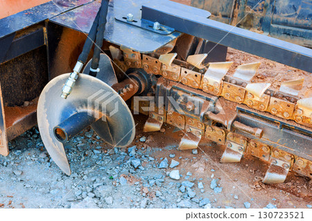 Close up of ground excavation tool on heavy machinery, highlighting its metal blades 130723521