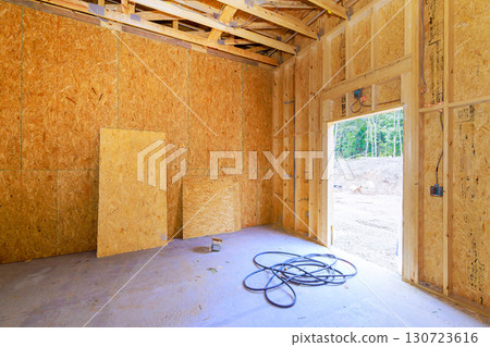 Interior view of construction site wooden walls beams tools, highlighting ongoing building work in rural area. 130723616