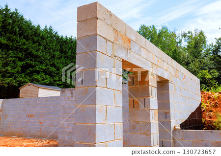 Blocks are being placed to form walls of structure in peaceful, outdoor construction site 130723657