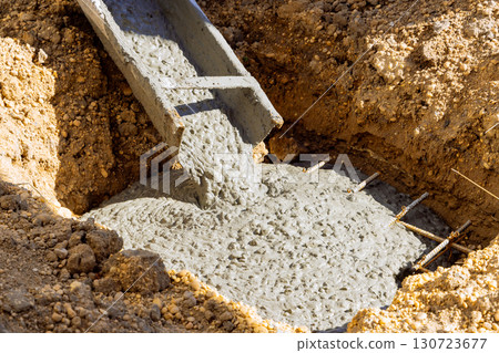 Fresh concrete fills foundation hole on works day, marking progress on new building project. 130723677