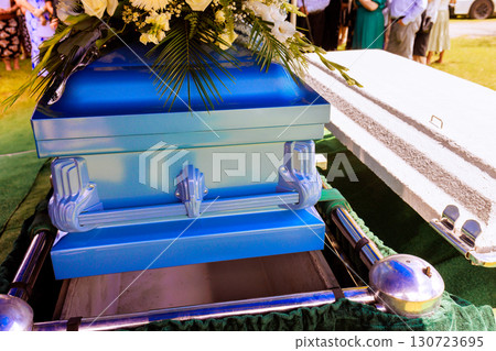 Family, friends gather to pay their respects as casket is lowered during an emotional farewell ceremony. 130723695