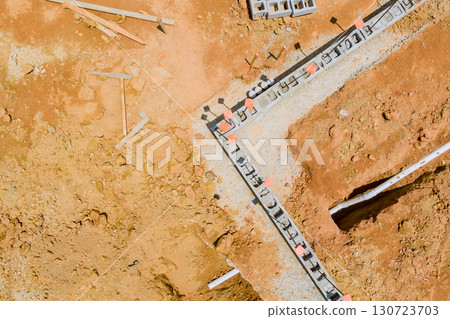 Workers are busy laying foundation for new building at construction site under works day. 130723703