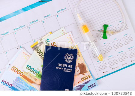 Won cash currency South Korean passport are laid out alongside calendar for organizing upcoming travel plans. 130723848