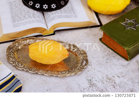 1 August 2025 Jerusalem Israel Etrog citrus fruit on open prayer book religious text with Star of David emblem. Traditional Jewish holiday symbols including kippah tallit for Sukkot festival 1 August 2025 Jerusalem Israel Etrog citrus fruit on open prayer book religious text with Star of David emblem. Traditional Jewish holiday symbols including kippah tallit for Sukkot festival 130723871